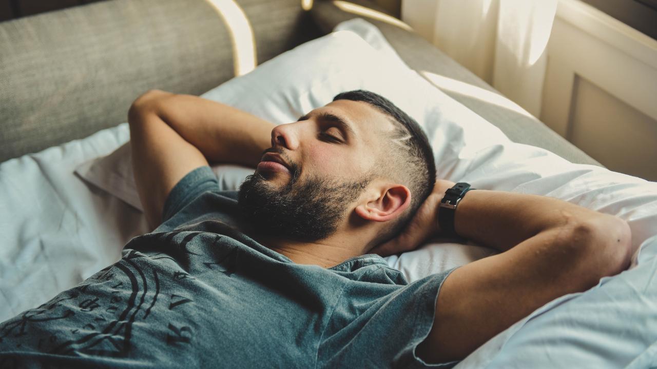 Man sleeping with hands behind head