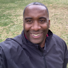 Black man smiling in park.